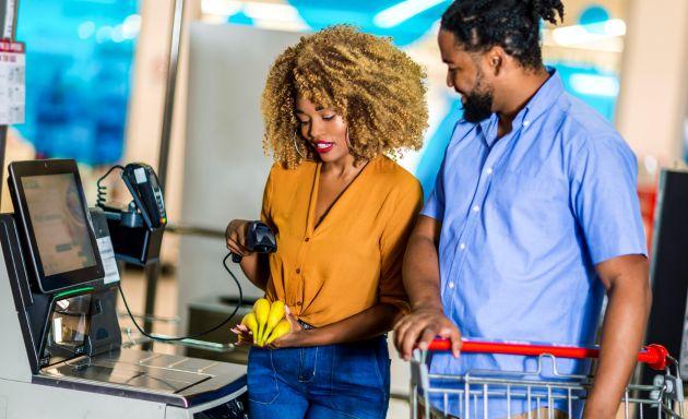 Couple at a self checkout scanning bananas